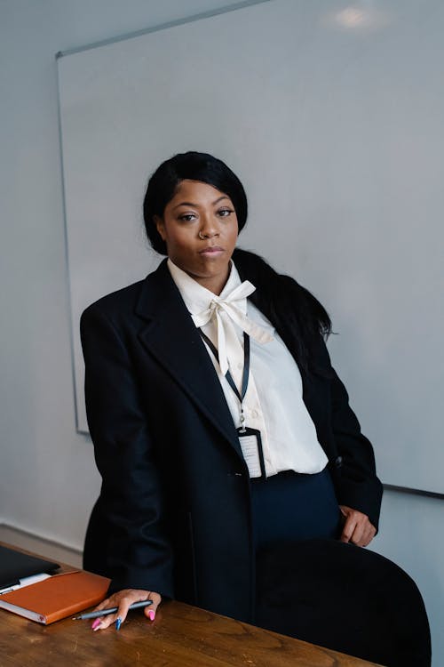 Sharply dressed stylish business woman walking portrait in suit at office  financial workplace. african american female Stock Photo