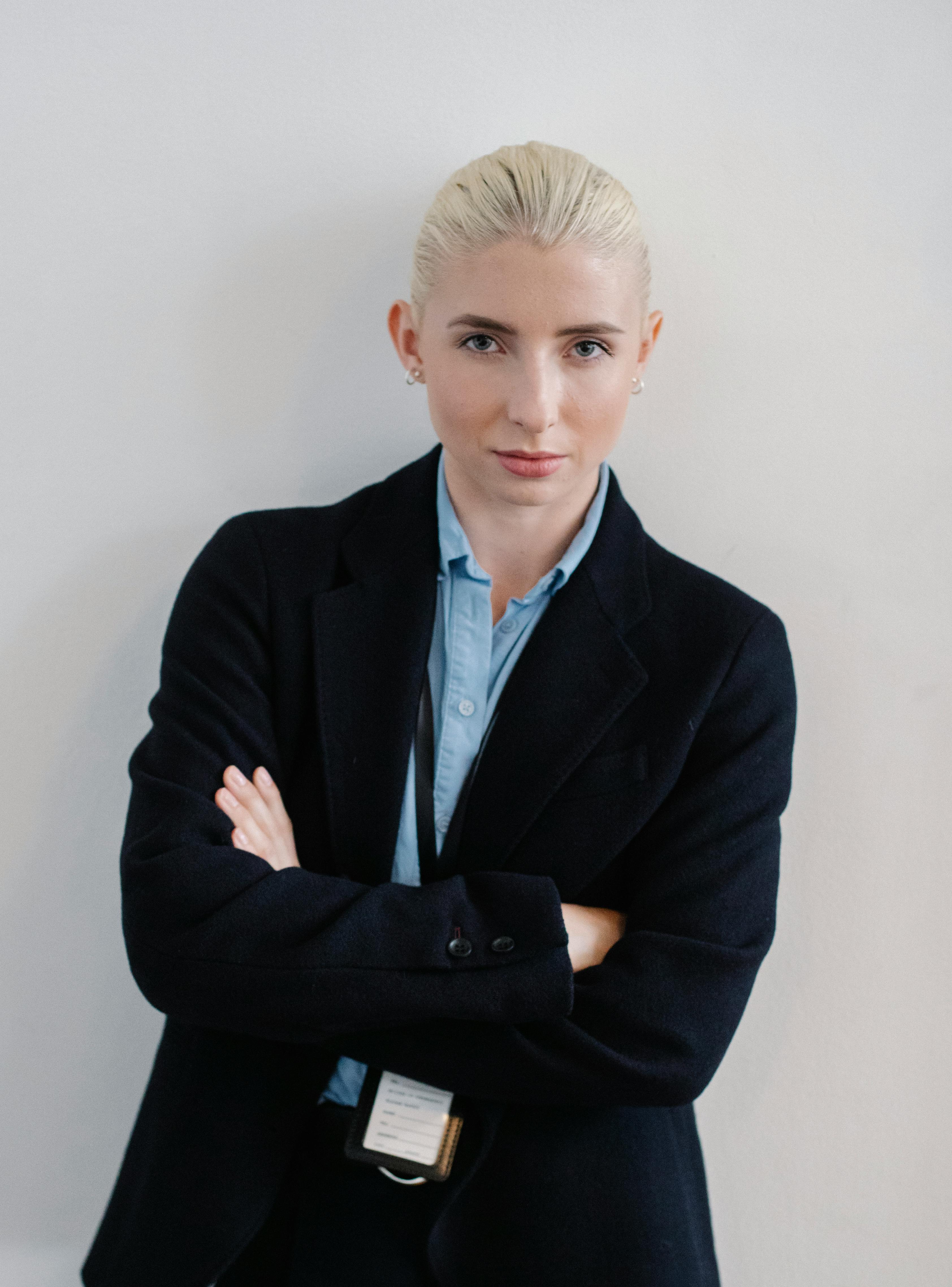 positive woman in formal clothes standing with arms crossed