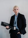 一位穿着正式服装的自信女商人在室内拿着一个黑色文件夹