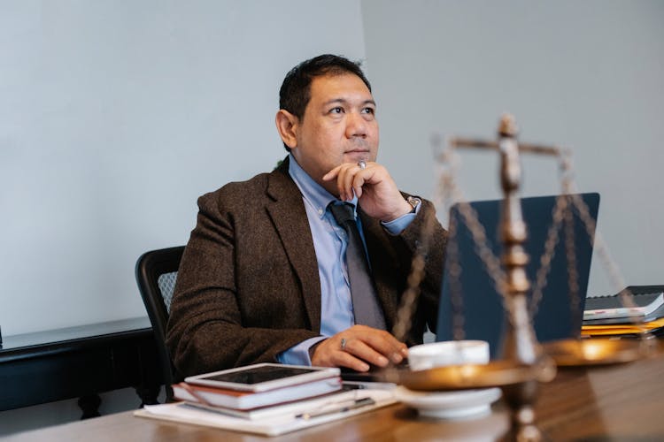 Asian Male Judge Working On Laptop In Office