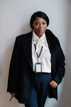 A confident businesswoman standing indoors, showcasing professionalism and style in formal attire.