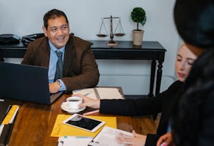 Content diverse law office workers wearing formal clothes gathering in conference room and discussing business strategy
