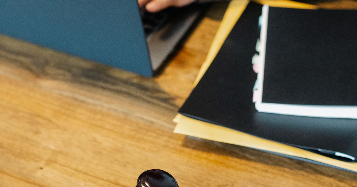 A legal professional working on a laptop beside a wooden gavel.