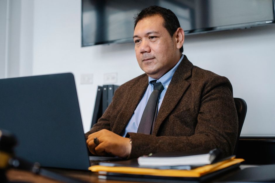 Empresario étnico Centrado Con Netbook Mientras Trabajaba En La Oficina