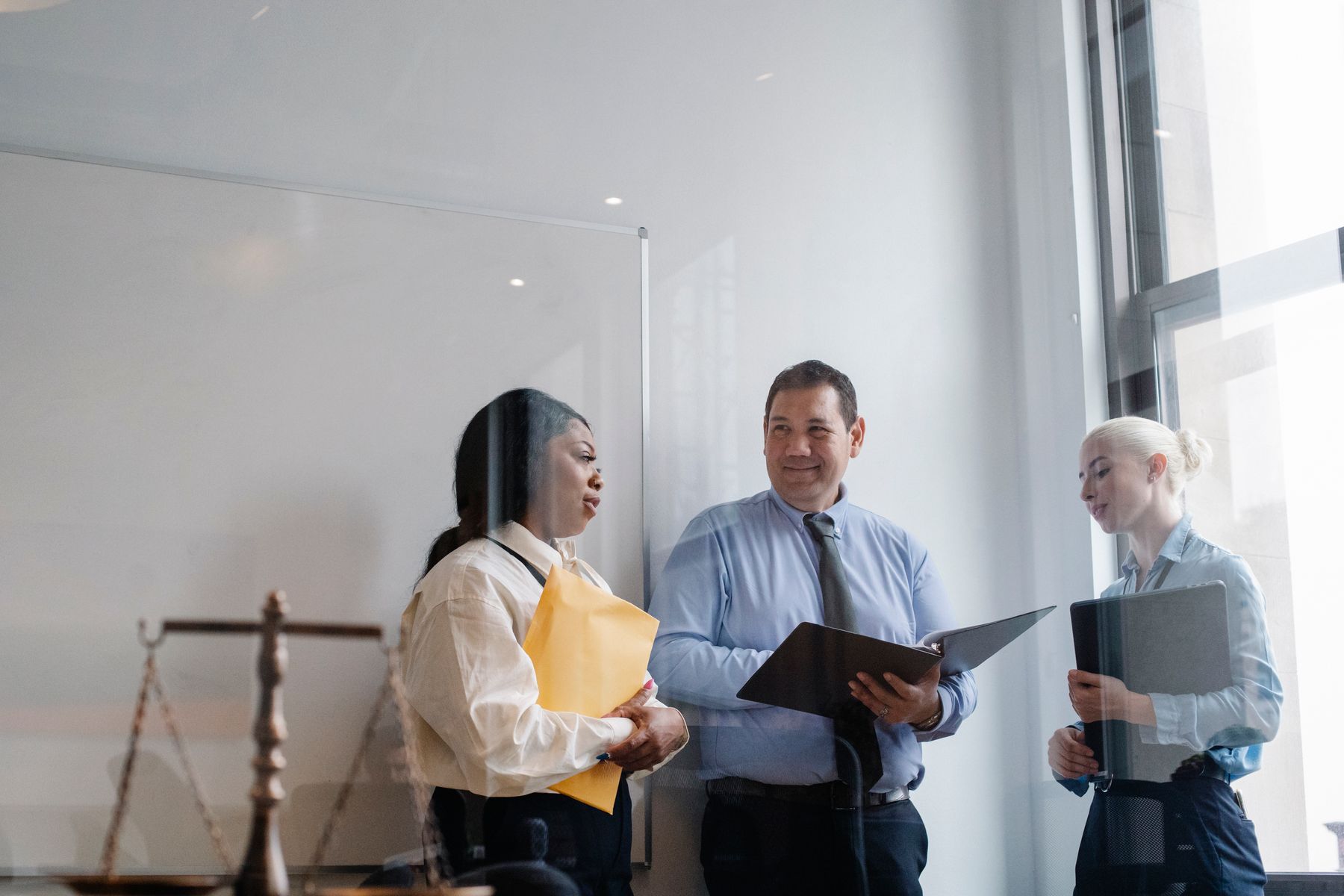 Legal professionals discussing case documents and law firm strategy in a modern office