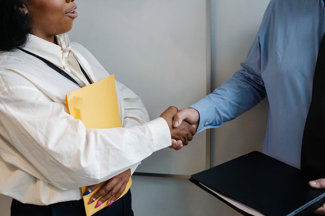 Free Diverse coworkers shaking hands after meeting Stock Photo