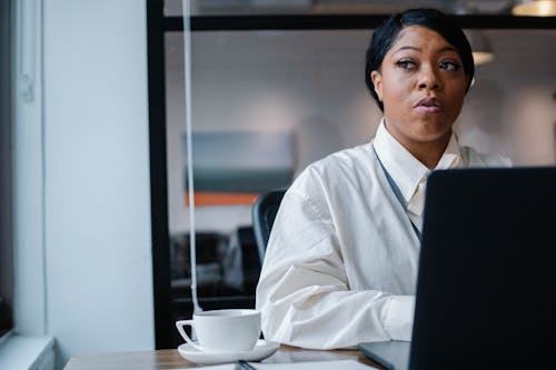 Free Thoughtful black businesswoman working on project in office Stock Photo