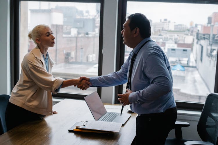 Young Woman Shaking Hands With Boss After Business Presentation