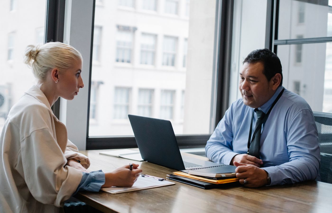 Two professionals engaged in a job interview discussion in a modern office setting.