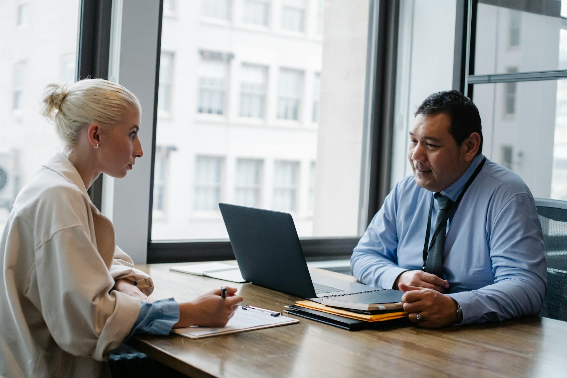 Two professionals engaged in a job interview discussion in a modern office setting.