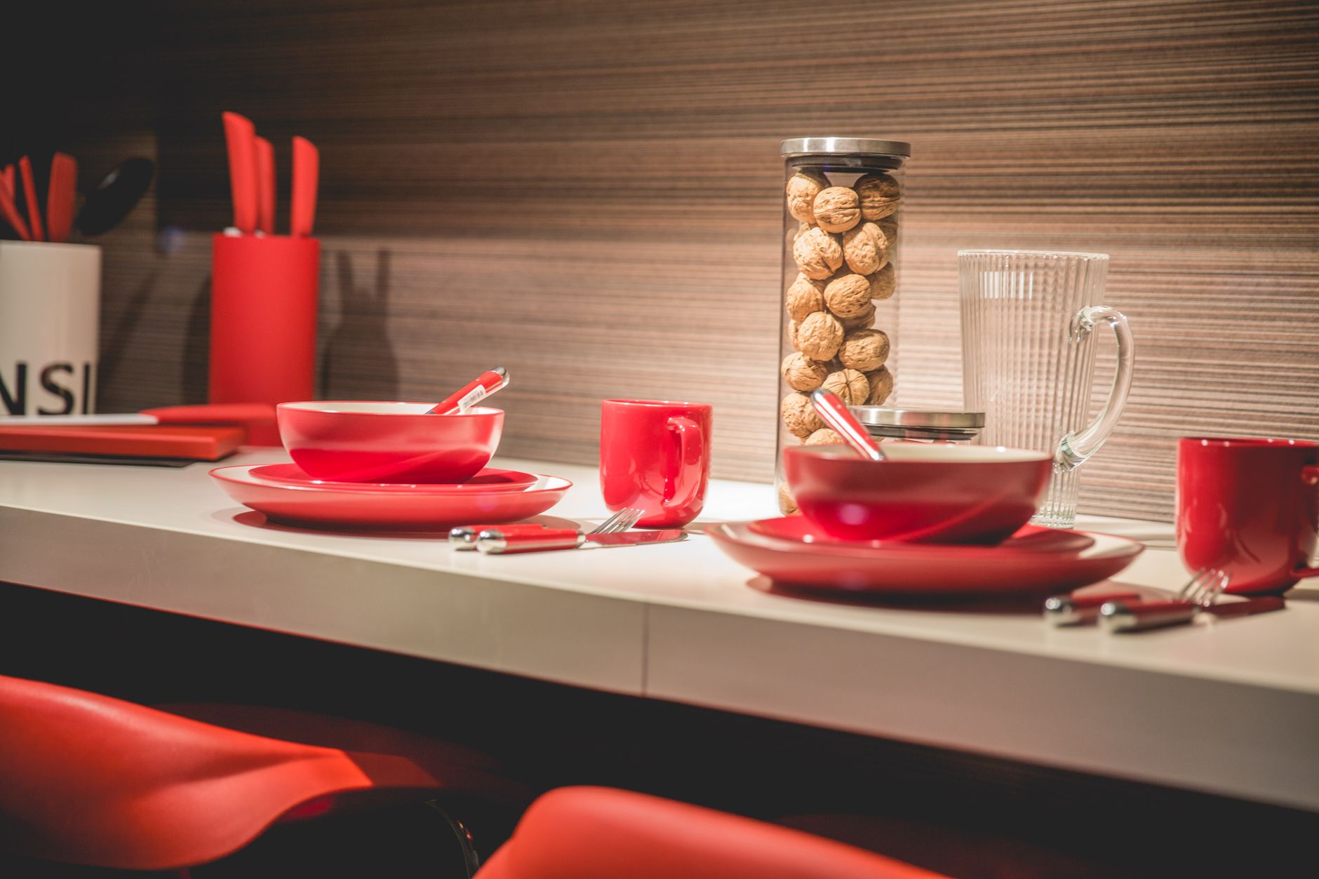 Stylish red dining setup with contemporary tableware and decor indoors.