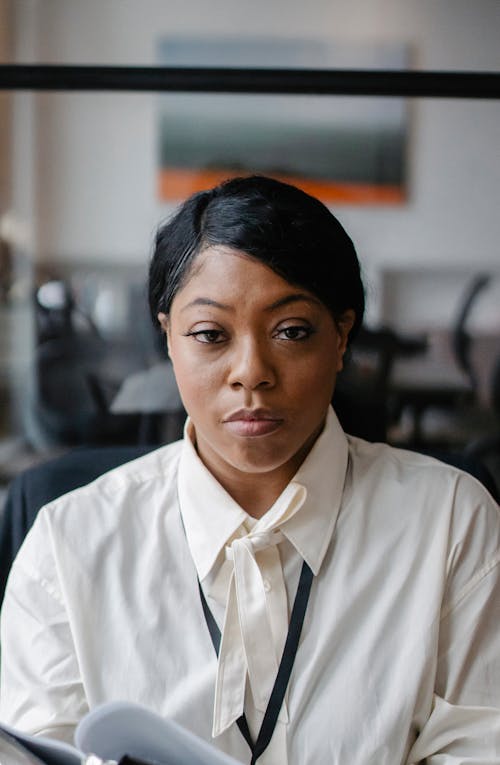 Femme Noire Sérieuse Avec Des Papiers Au Bureau