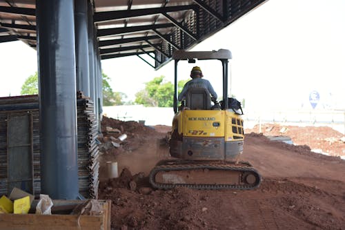 Free A Man Operating a Heavy Machinery on a Construction Site Stock Photo