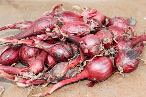 Pile of fresh shallots on dry terrain on street