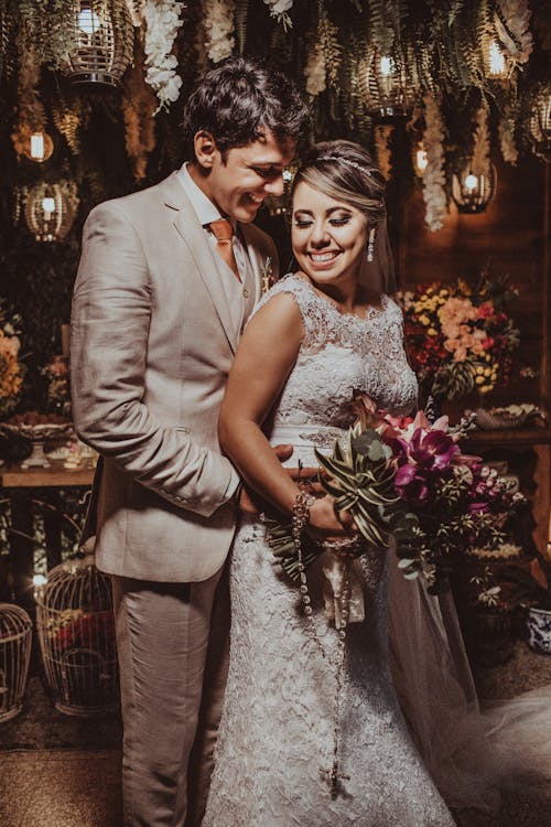 Happy smiling newlyweds hugging on wedding celebration