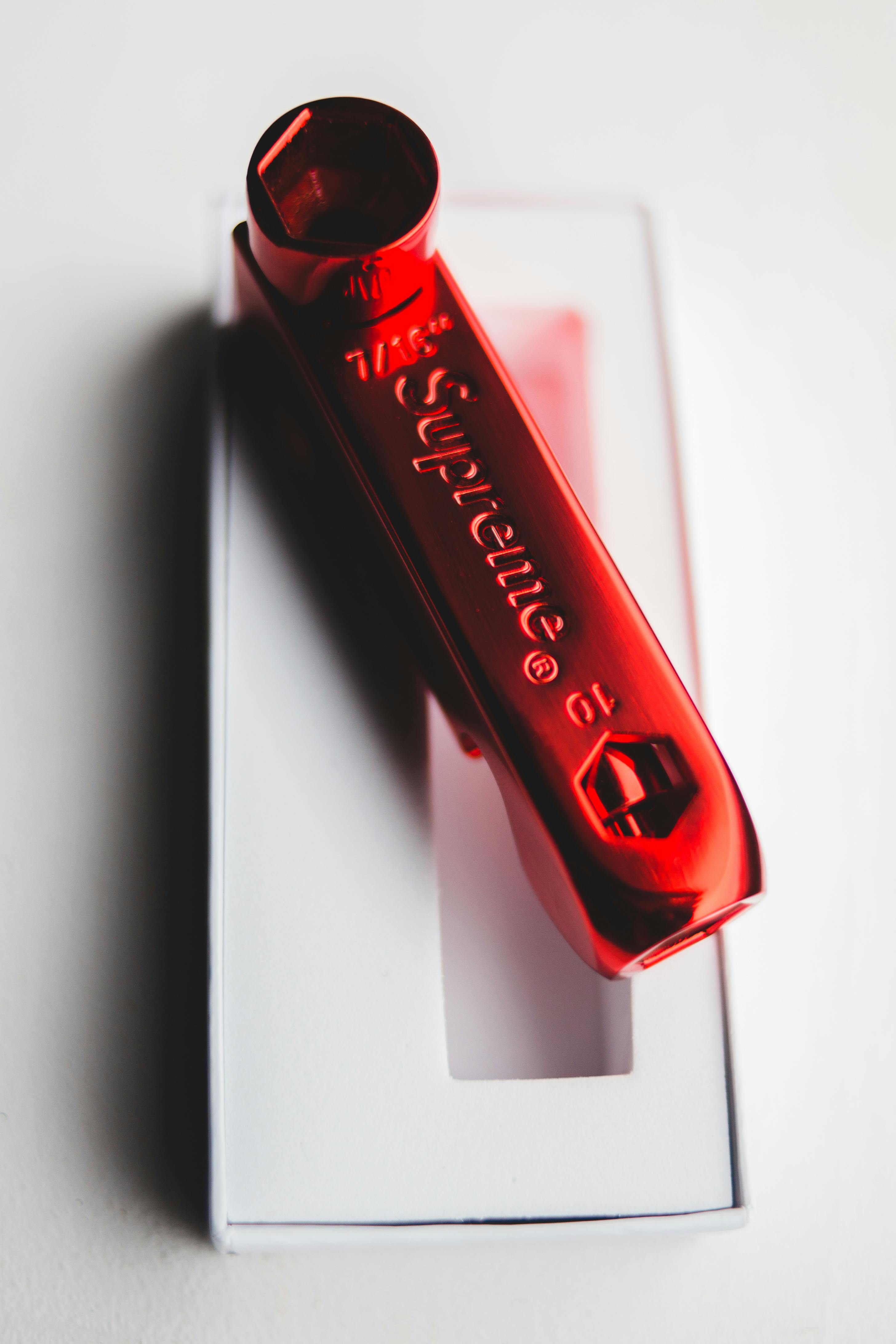 Stylish red skate key pipe placed on gift box · Free Stock Photo