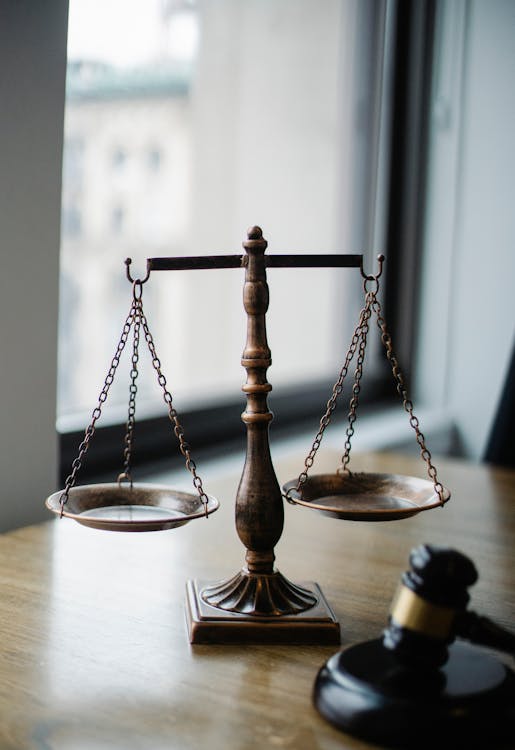 Free Decorative judgement scale and gavel placed on desk in light lawyer office against window Stock Photo