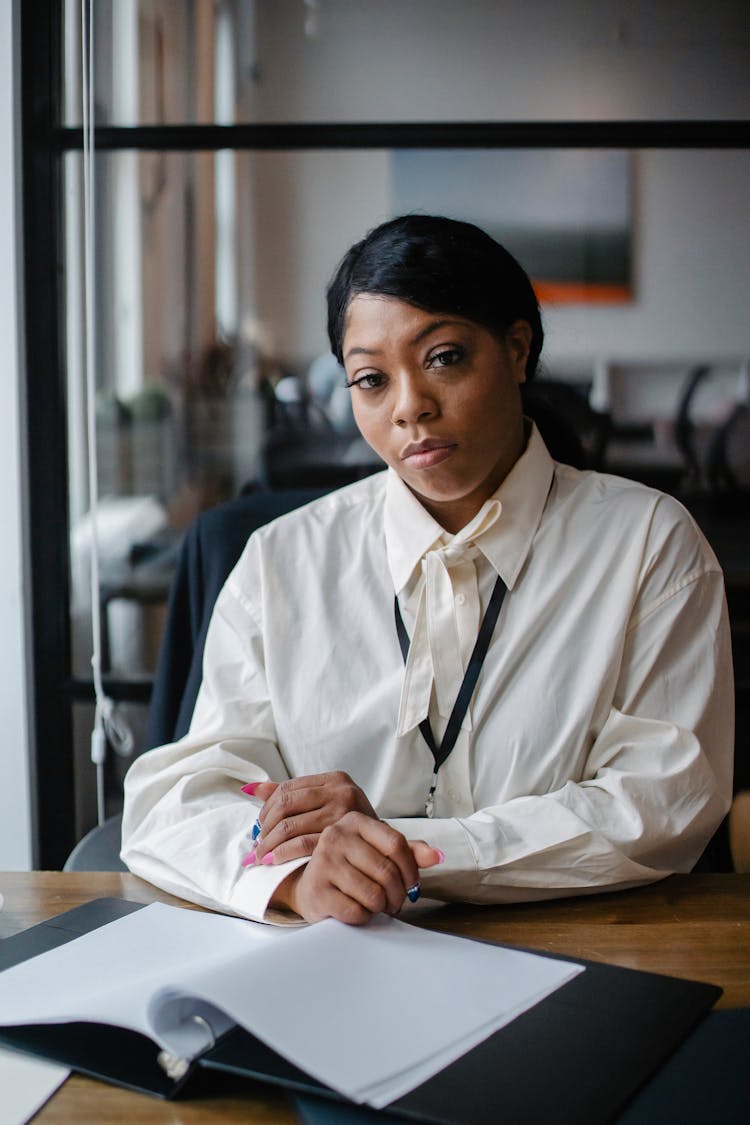 Confident Black Businesswoman Sitting At Desk In Modern Workplace