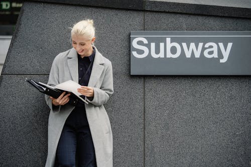 Free Happy businesswoman reading documents near subway station Stock Photo