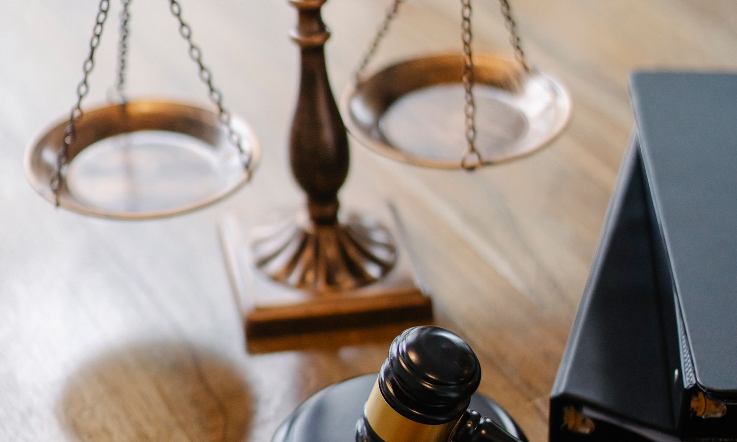 Balanza de la justicia y mazo de juez sobre una mesa de despacho