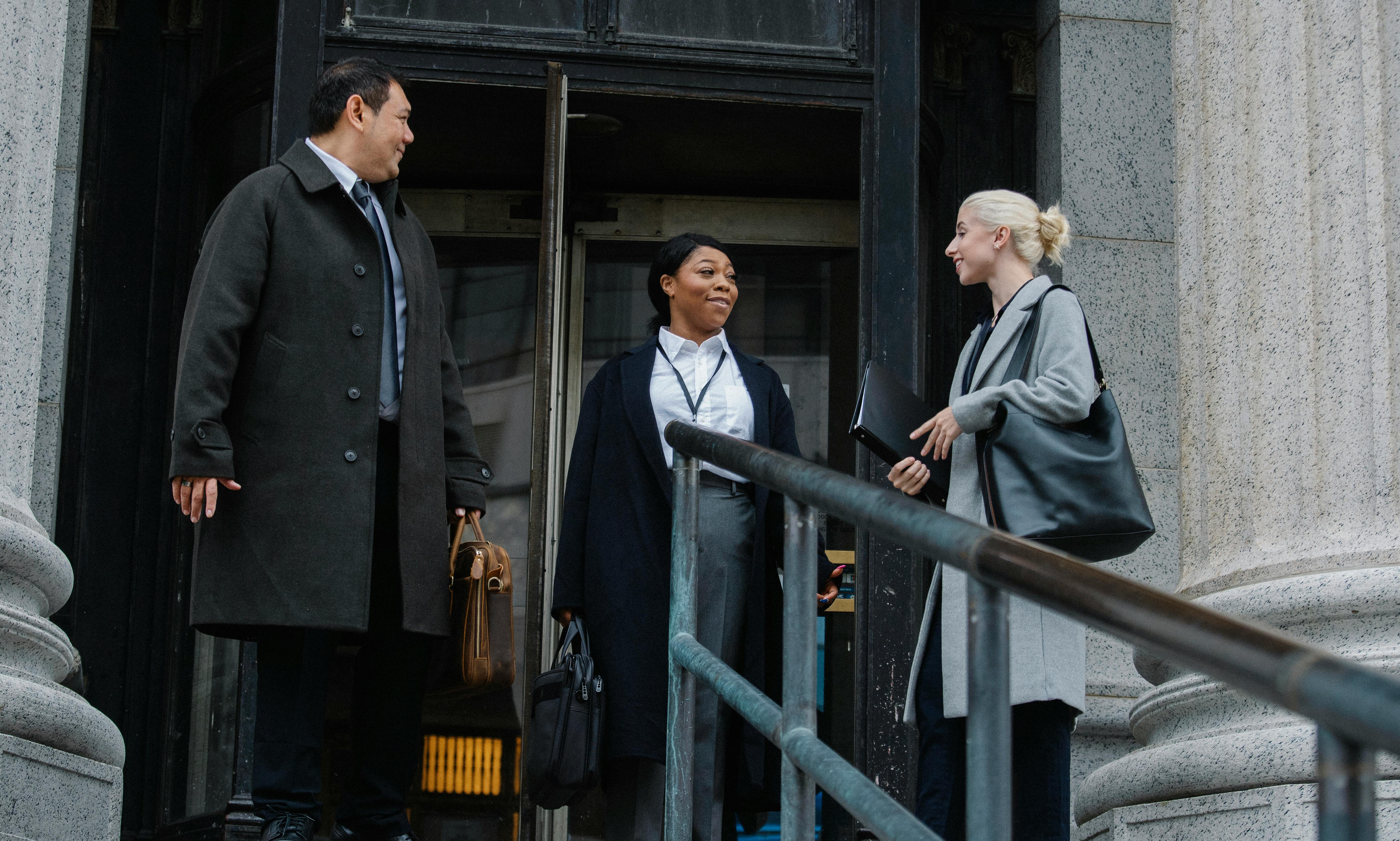 multiracial coworkers chatting near building after work