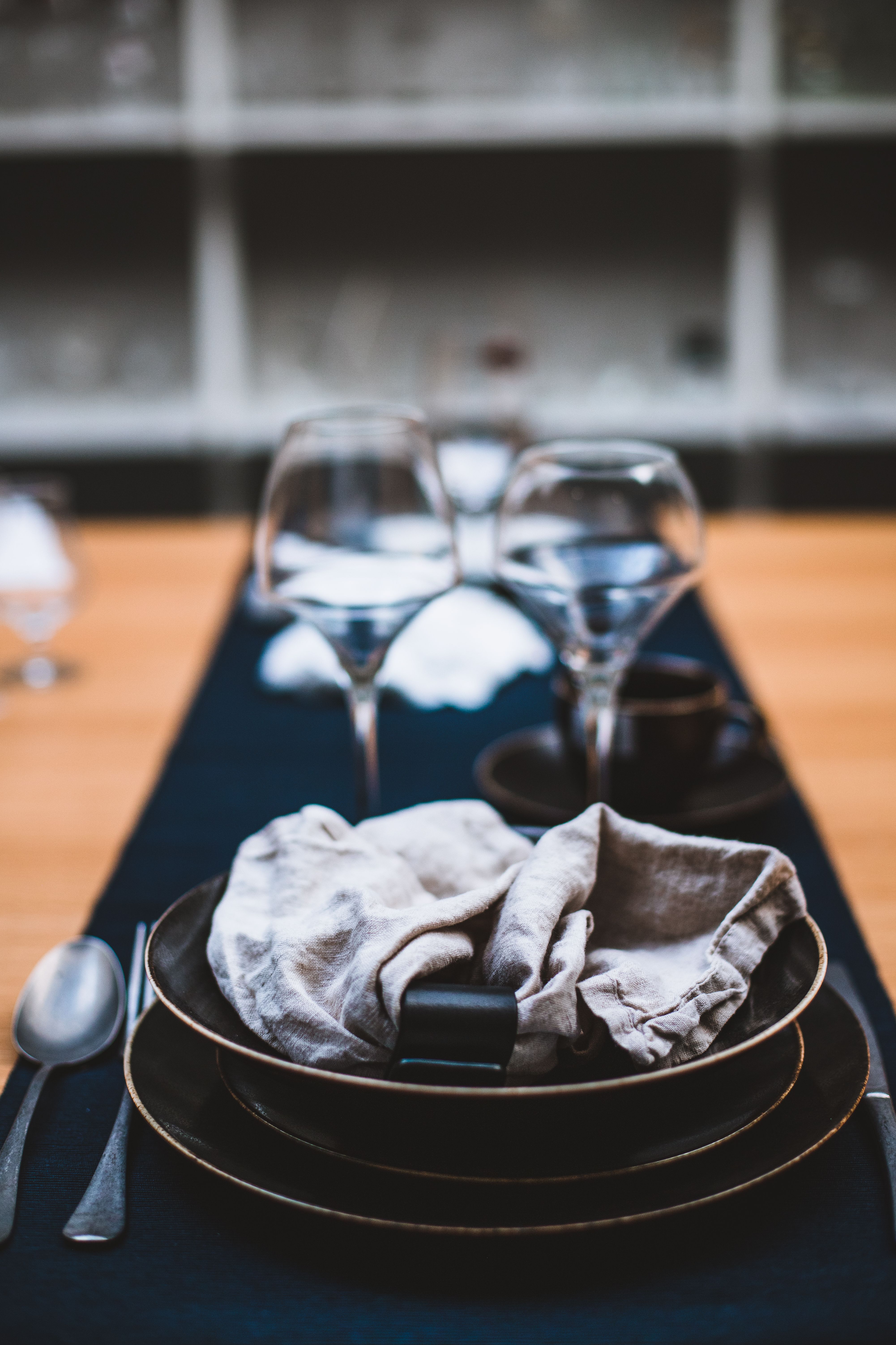 Stylish table setting with earthenware plates and glasses, creating a sophisticated dining ambiance.
