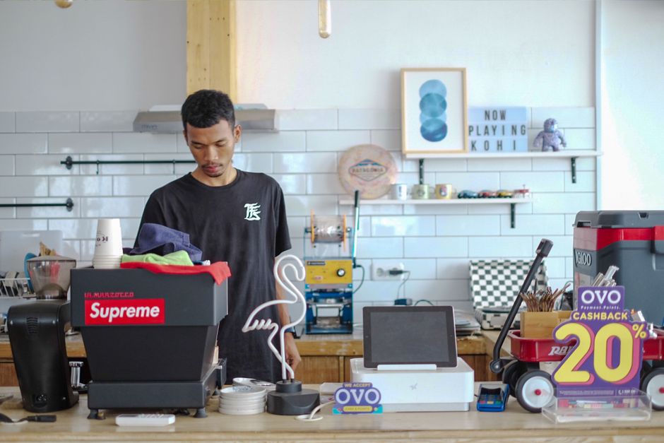 Young barista in Indonesia preparing coffee in a stylish modern café interior. Young barista in Indonesia preparing coffee in a stylish modern café interior.