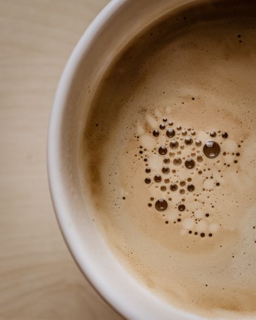 Free Close-up view of a creamy coffee with frothy bubbles, showcasing the rich texture. Stock Photo