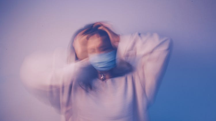 Woman In Face Mask Touching Head In Anxiety