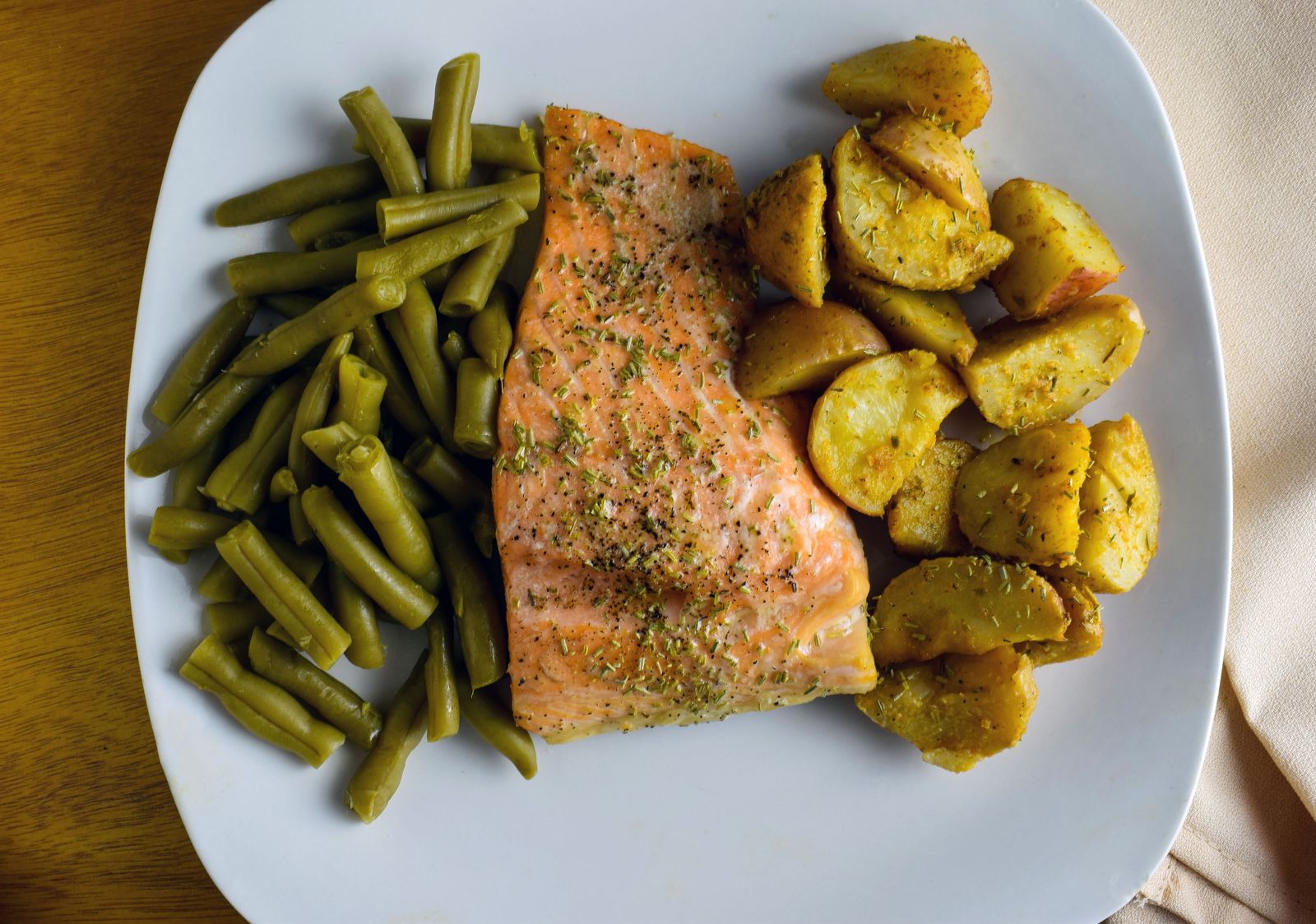Overhead plate of baked salmon with green beans and roasted potatoes. Photo by douglas miller on Pexels.