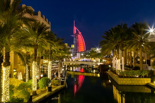 Captivating nighttime view of the Burj Al Arab with illuminated palm trees and canal in Dubai.