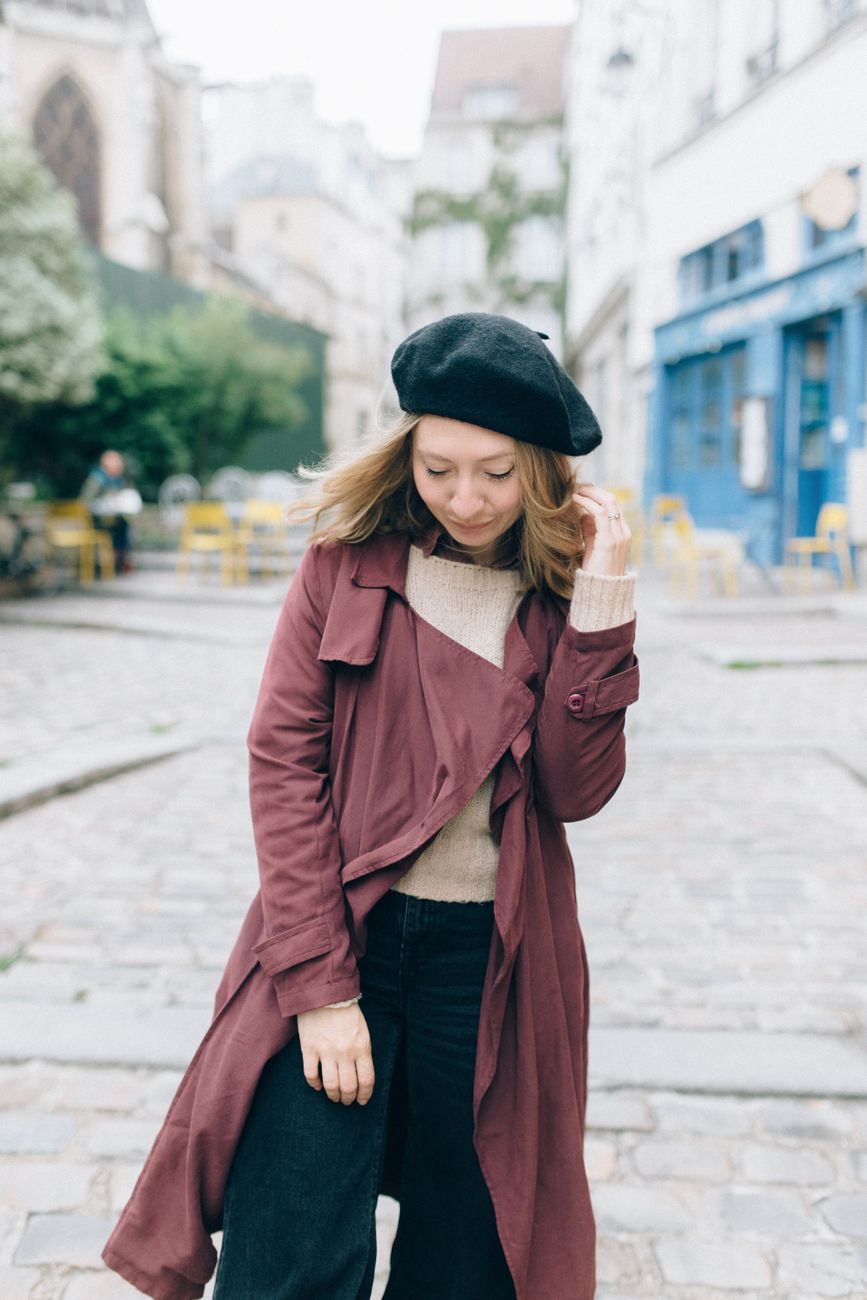 Graceful woman in a beret and coat showcasing chic street style in Paris.