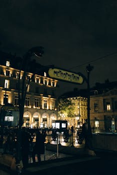 巴黎地铁入口的迷人夜景映衬着优雅的城市建筑