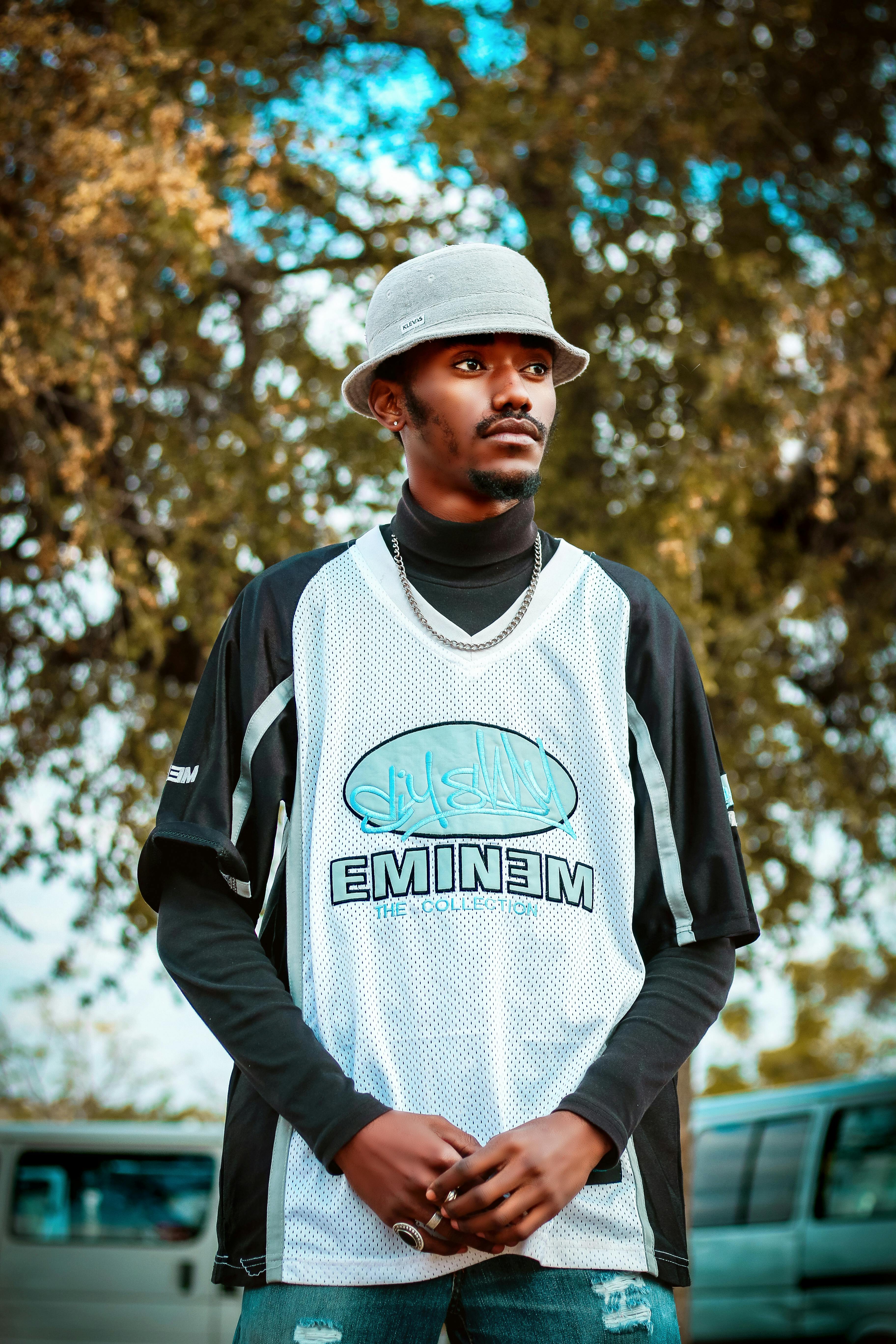 Free Stylish young man with bucket hat and jersey posing outdoors in Botswana. Stock Photo