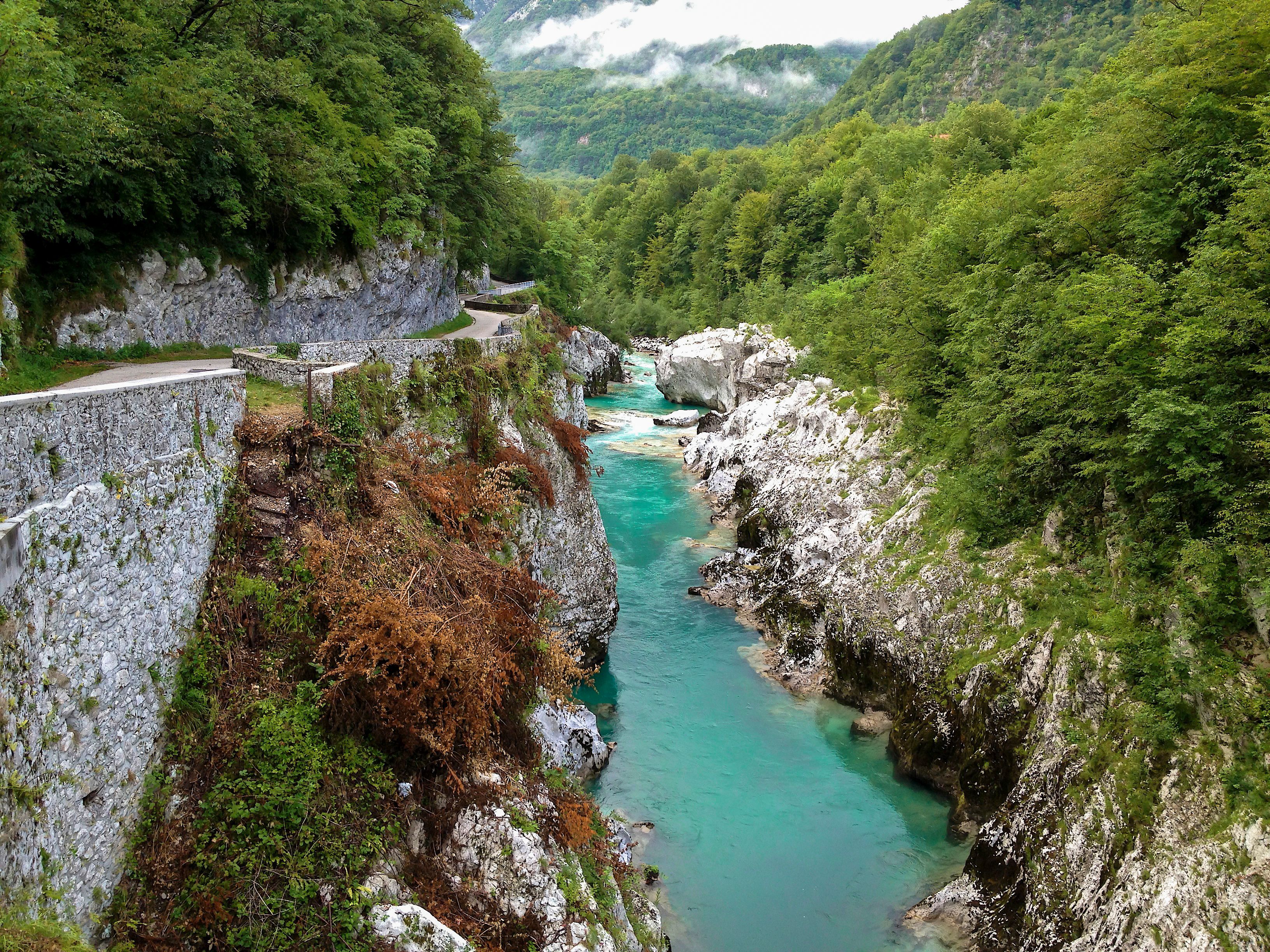 Beautiful view of the Soča River flowing through a canyon surrounded by lush greenery.
