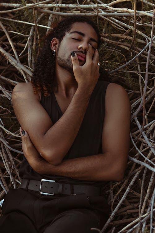 Free Stylish sensual black man resting on tree twigs Stock Photo