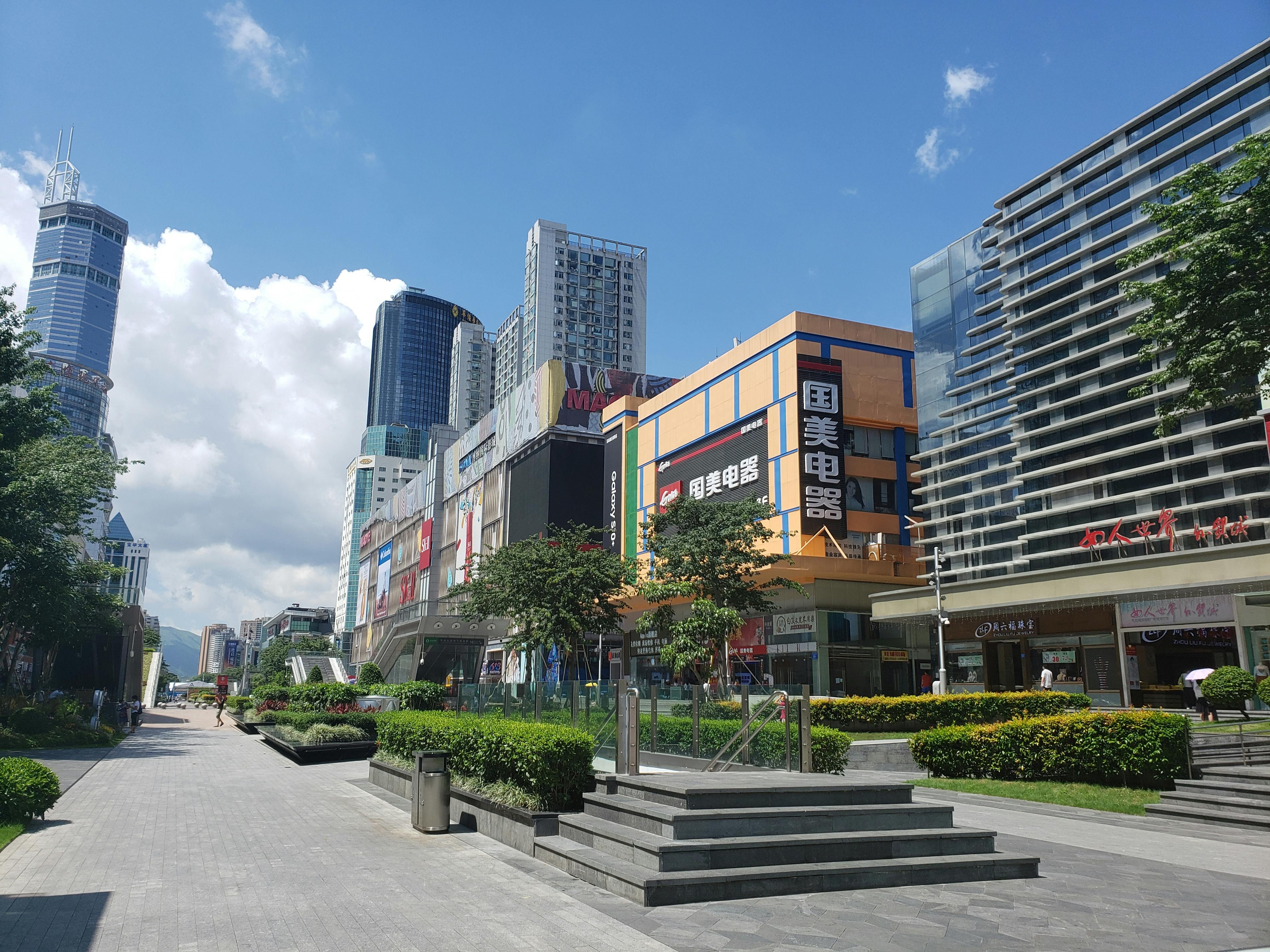 High-rise buildings and shopping malls in a bustling urban area of Shenzhen, China.