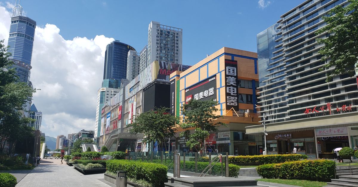 High-rise buildings and shopping malls in a bustling urban area of Shenzhen, China.
