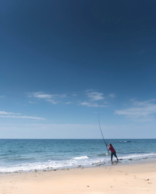 A Person Fishing on the Beach