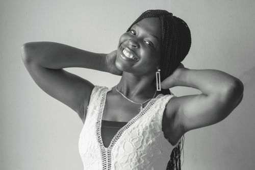 Free Black and white portrait of a smiling woman with cornrow braids, exuding joy and elegance. Stock Photo