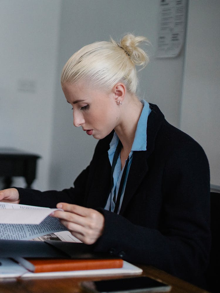 Content Serious Businesswoman Reading Important Report In Office