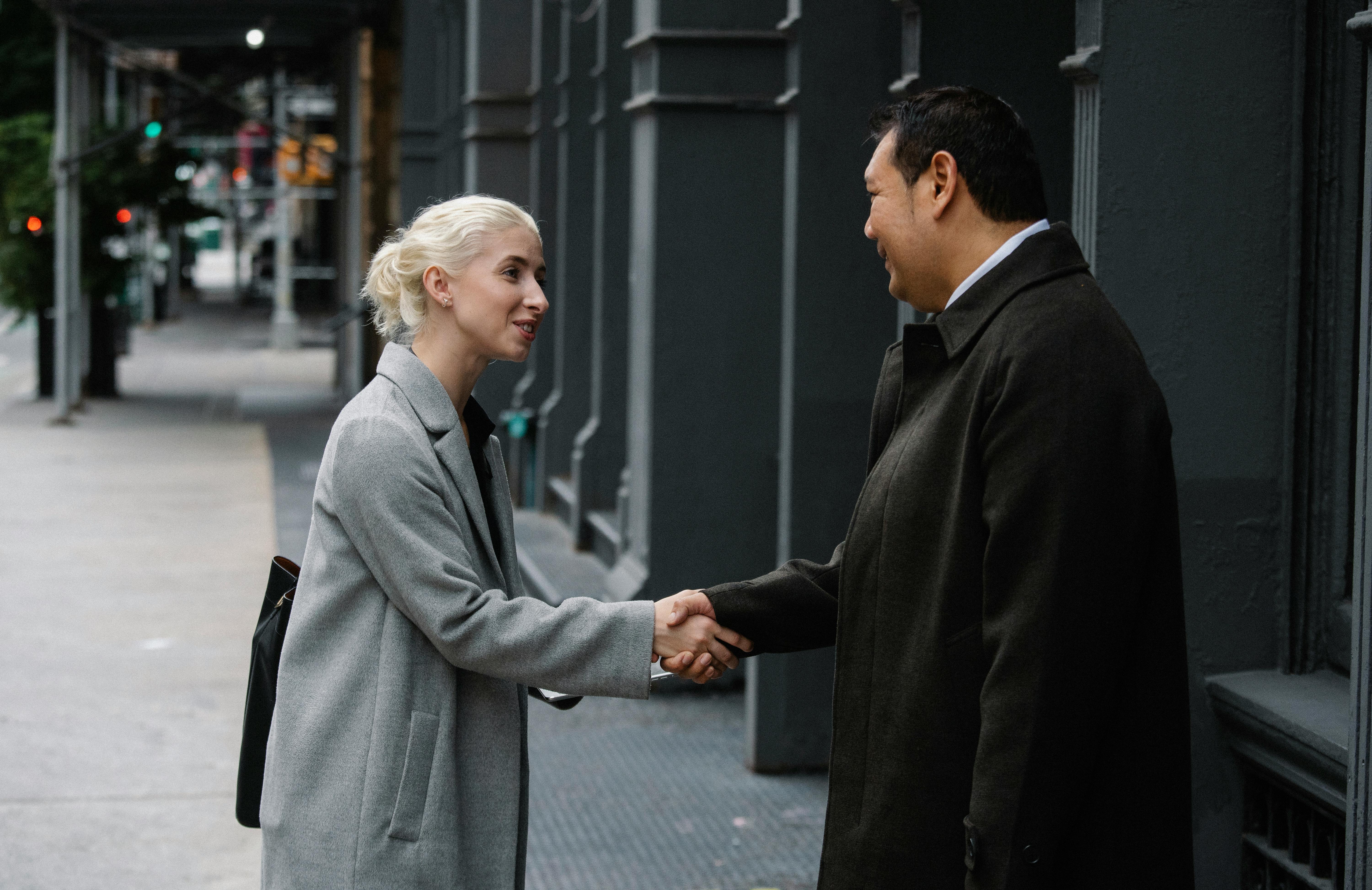 young businesswoman shaking hands with asian colleague