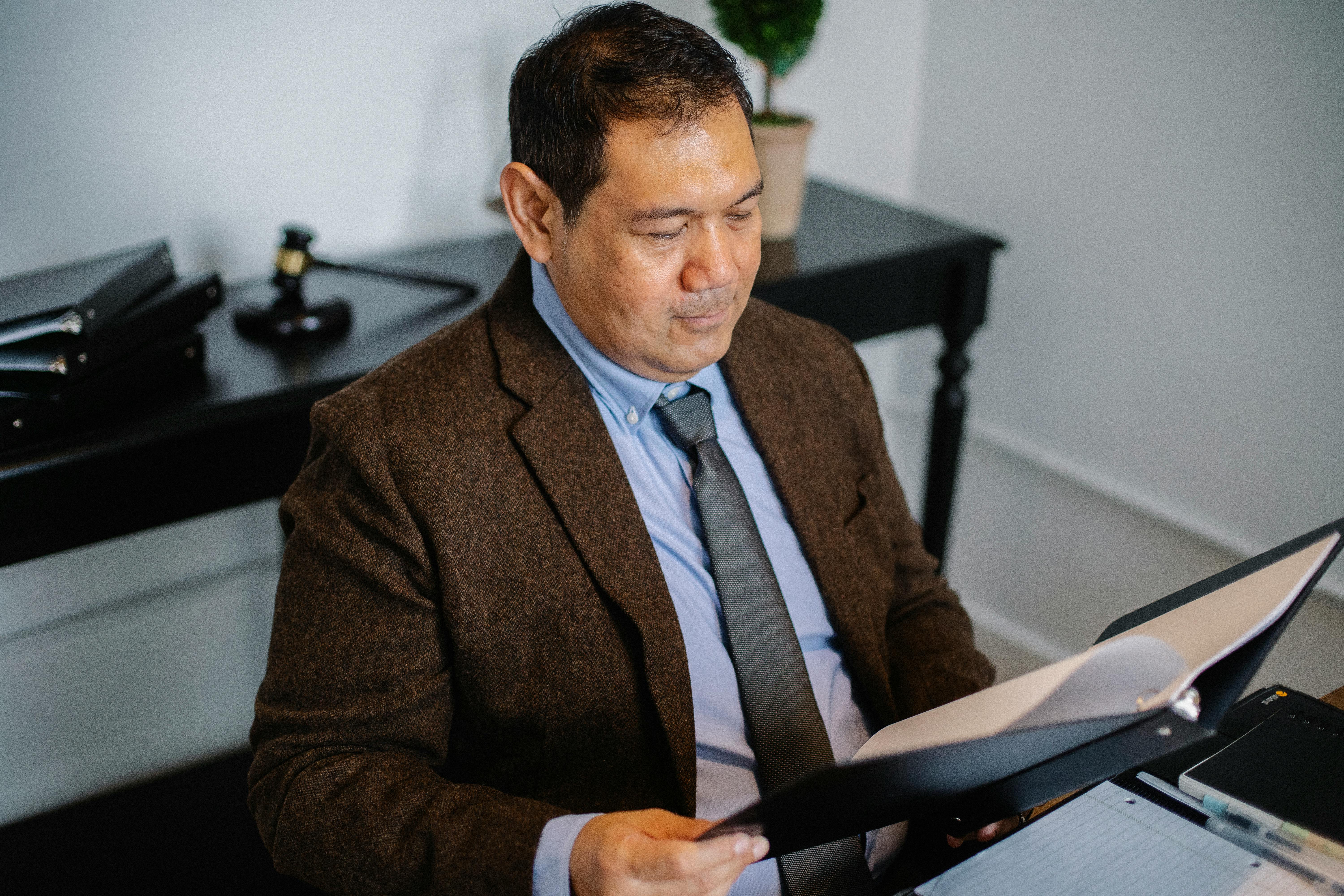 pensive asian lawyer examining report in office