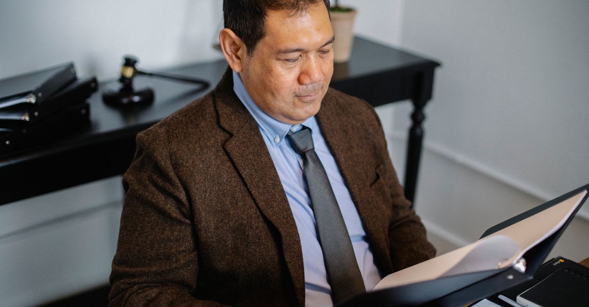 Hispanic man reviewing auto insurance documents at a desk in Orlando Florida office