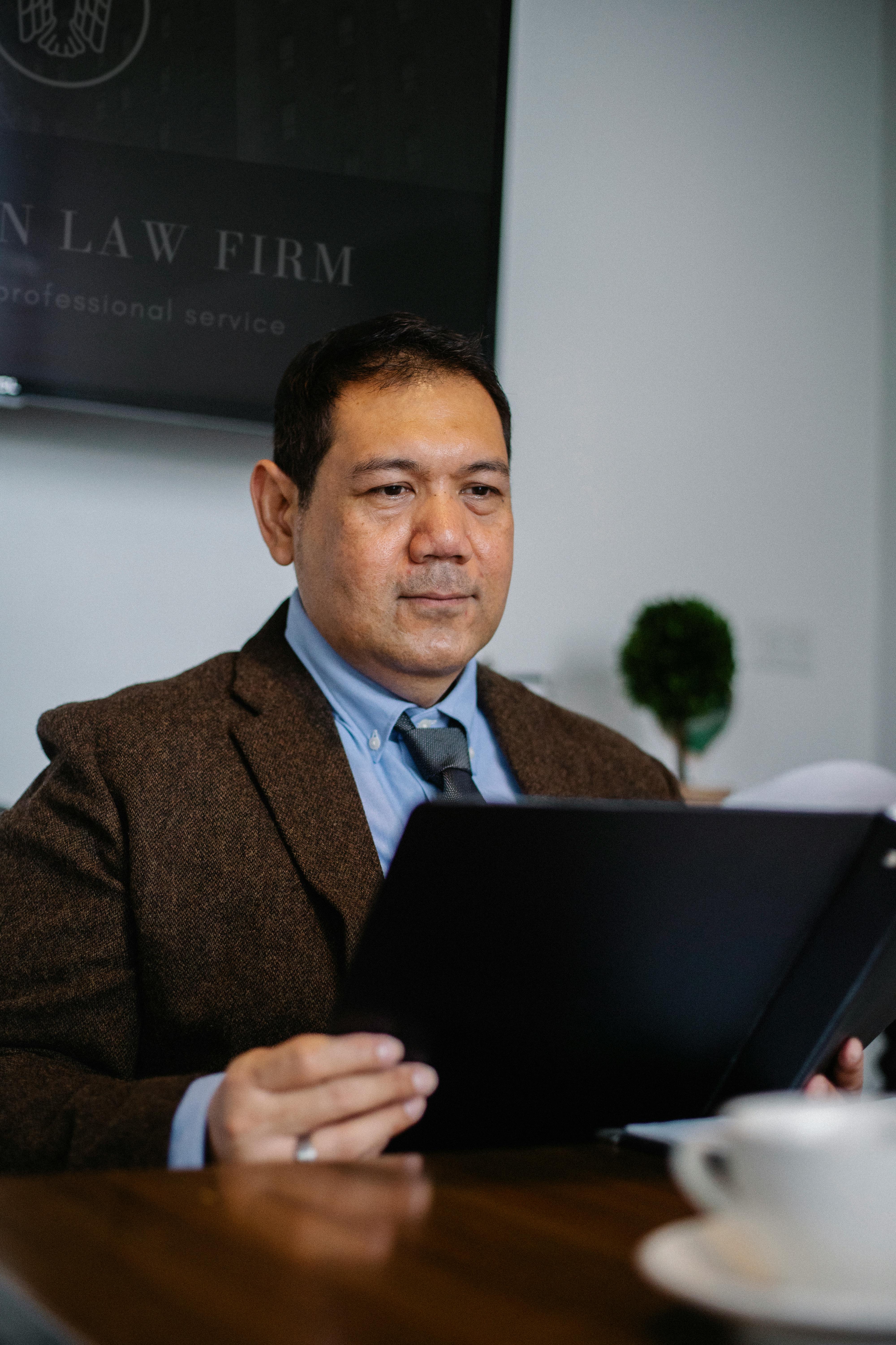 Pensive Asian lawyer examining report in office \u00b7 Free Stock Photo