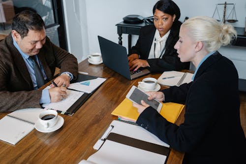 Diverse businesspeople discussing documents at table in office