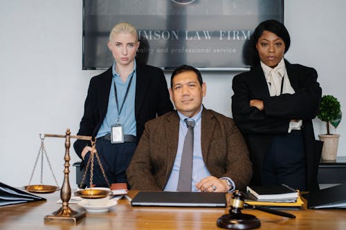 Free Group of diverse colleagues near table with gavel Stock Photo