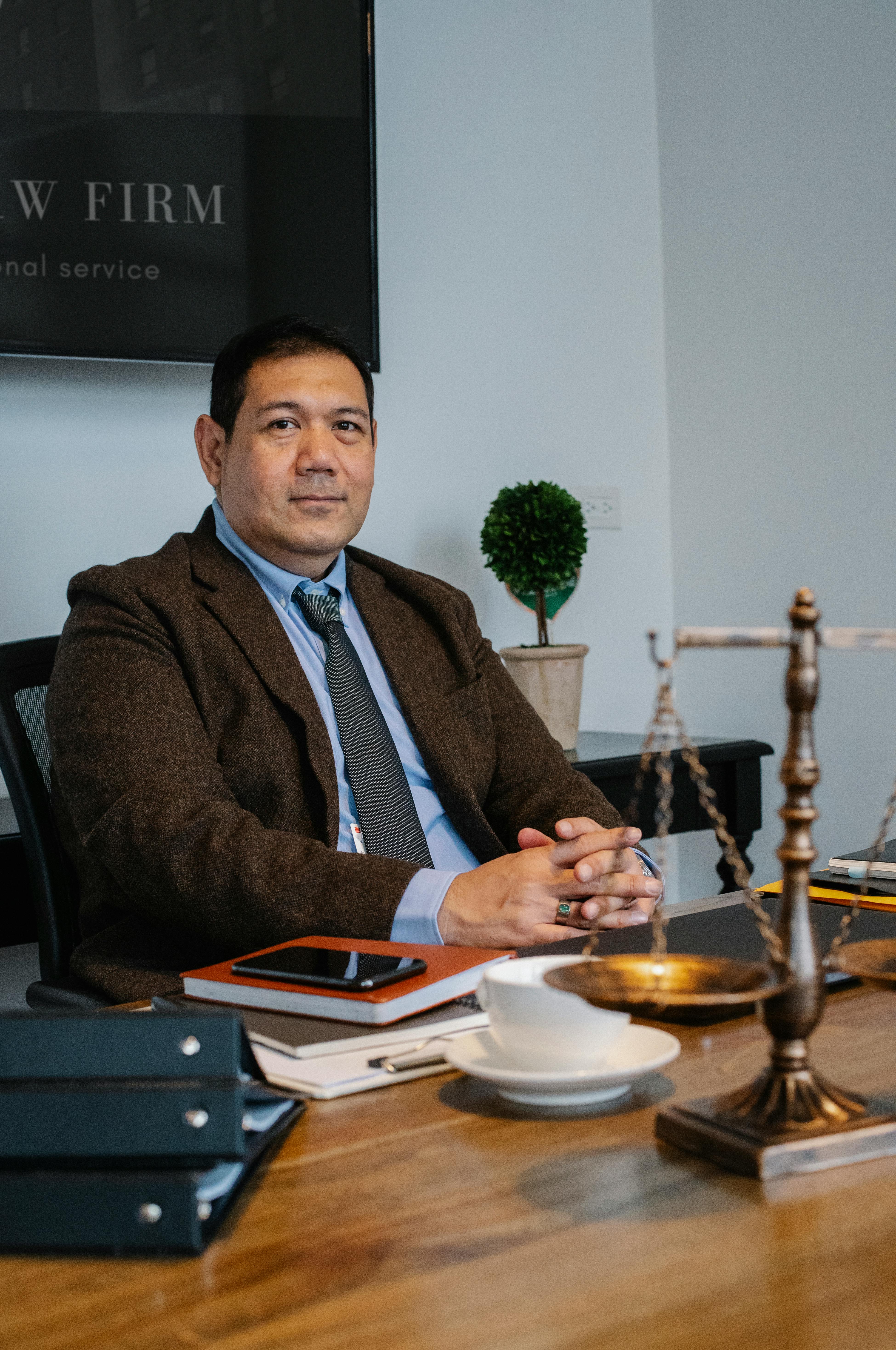 mature asian lawyer in formal outfit sitting at table