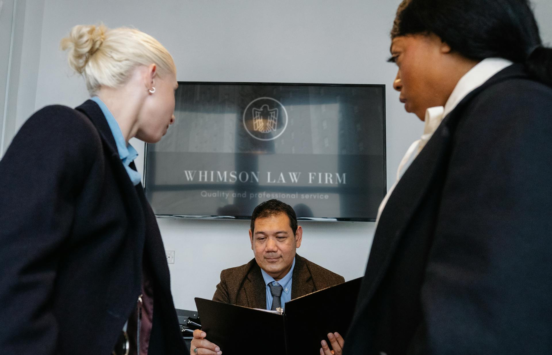 Diverse colleagues gathering in conference hall of law firm and discussing details of contract while working together