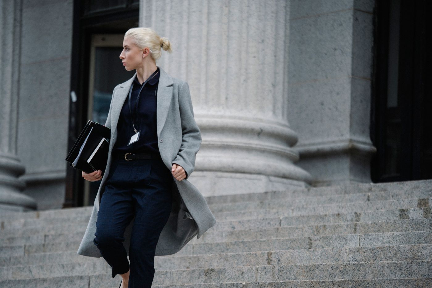 Professional carrying document folders outside a courthouse